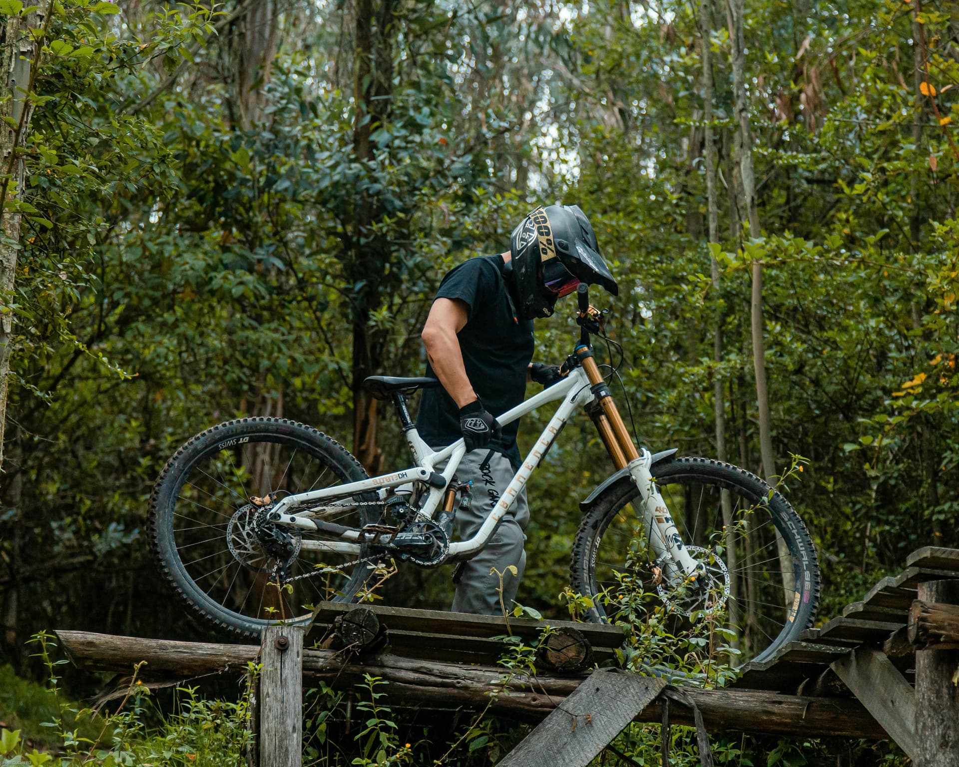 Mountain biker in full gear riding a forest trail in Ecuador, showcasing adventure and nature.