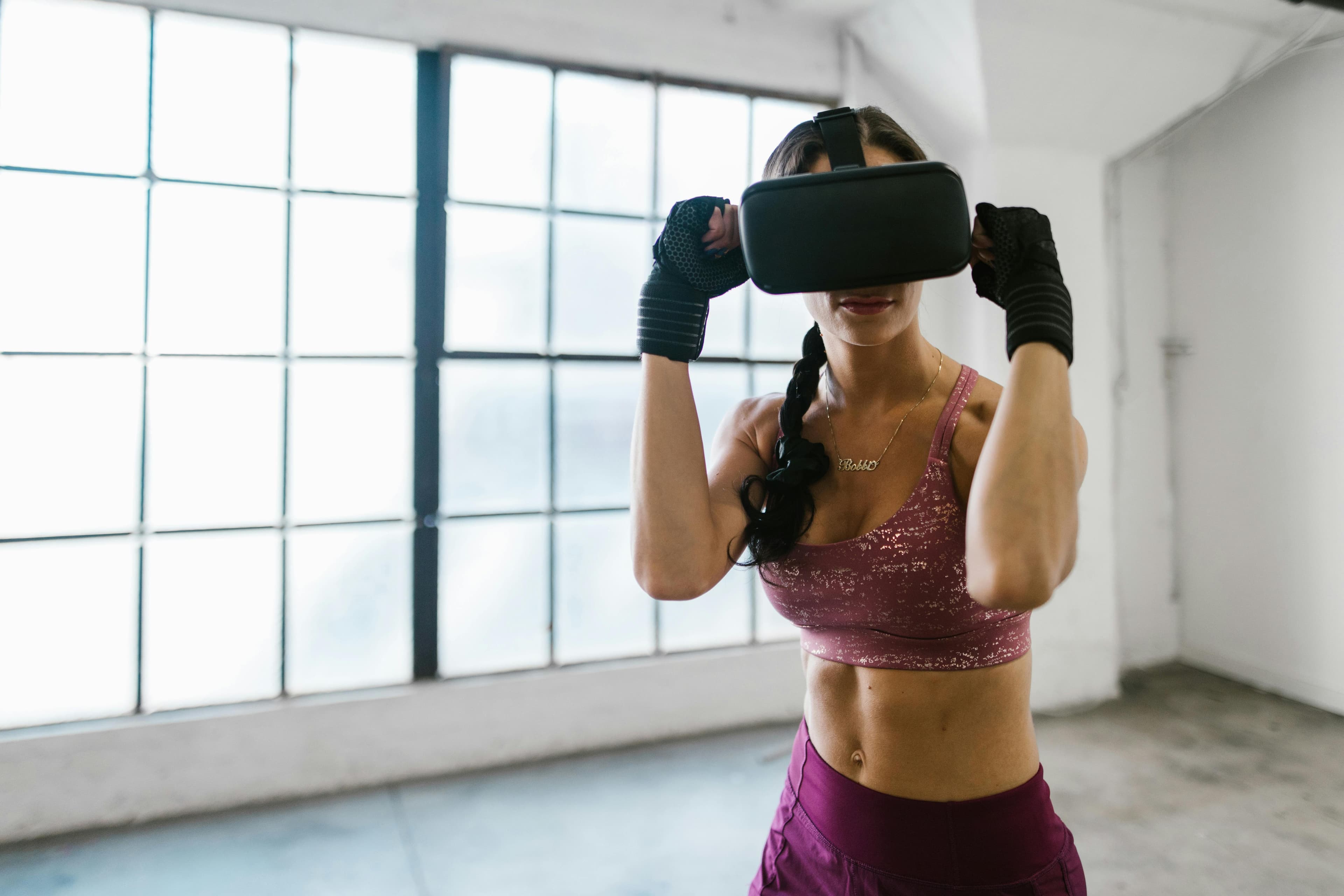 Woman uses VR headset during workout, blending technology with fitness in an indoor setting.