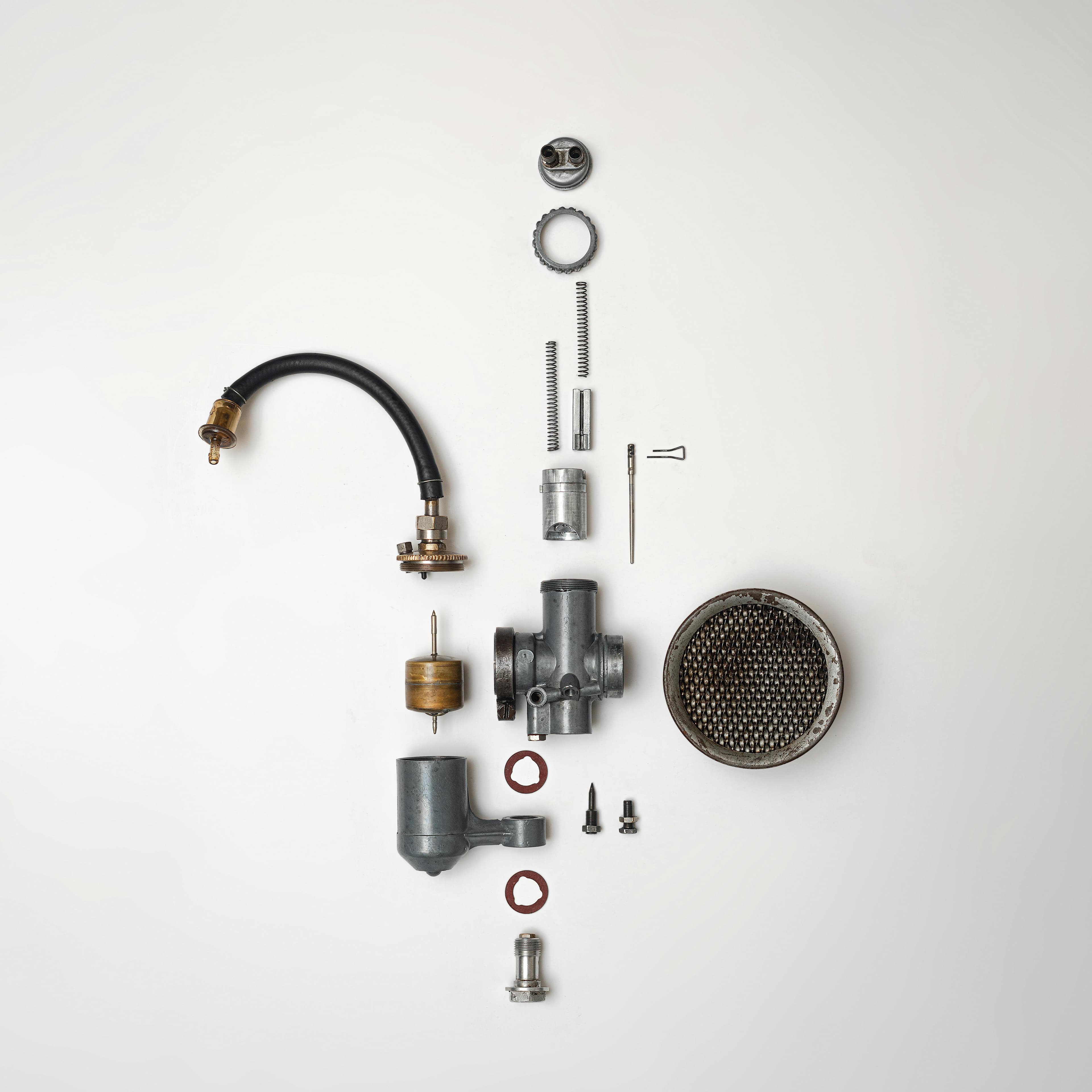 Flat lay of disassembled mechanical parts on a white background.